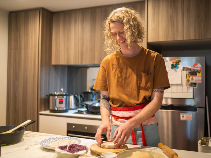 man folding Indian roti and smiling